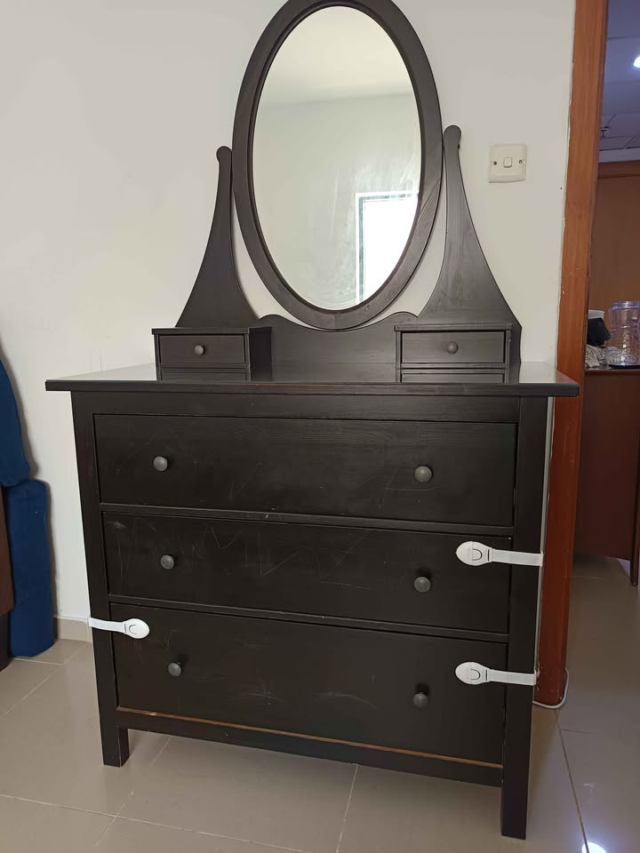 Dark wood dresser with oval mirror and three drawers