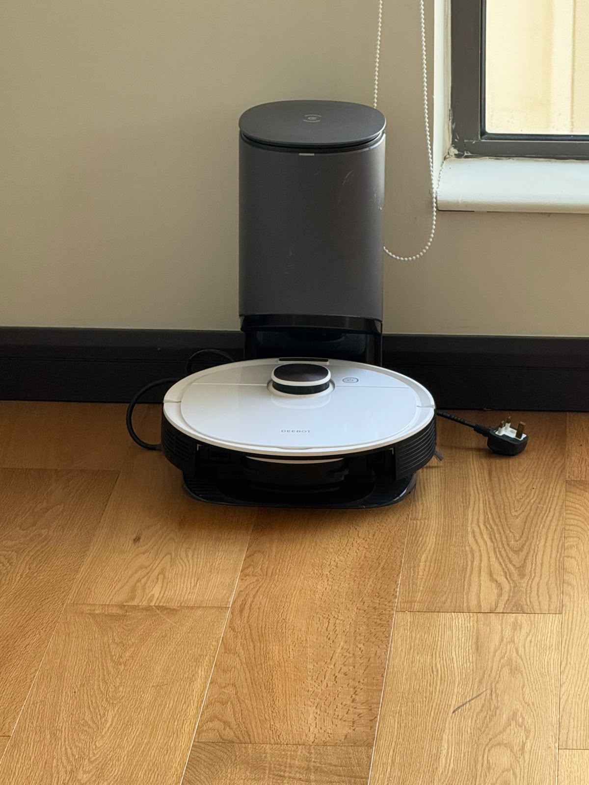 Ecovacs Deebot robot vacuum on charging dock with auto-empty station