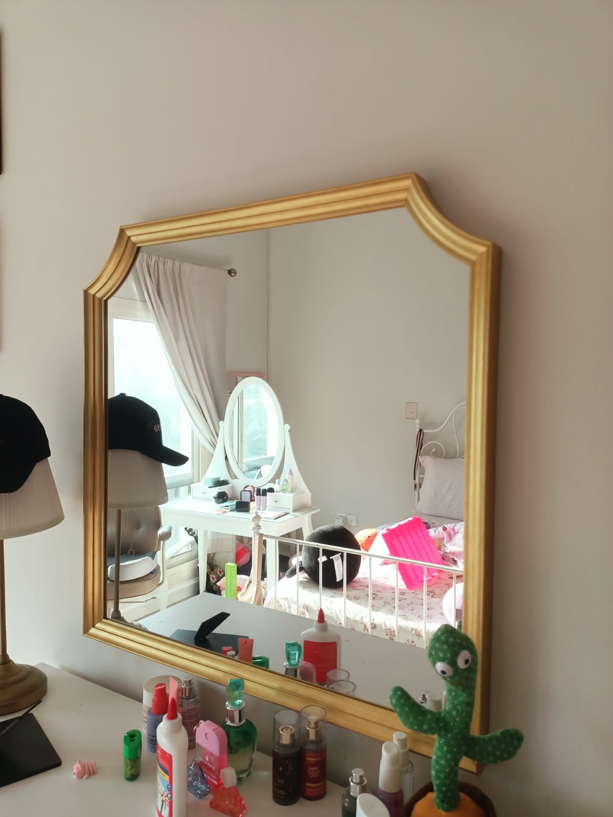 Original photo of gold-framed wall mirror above dresser