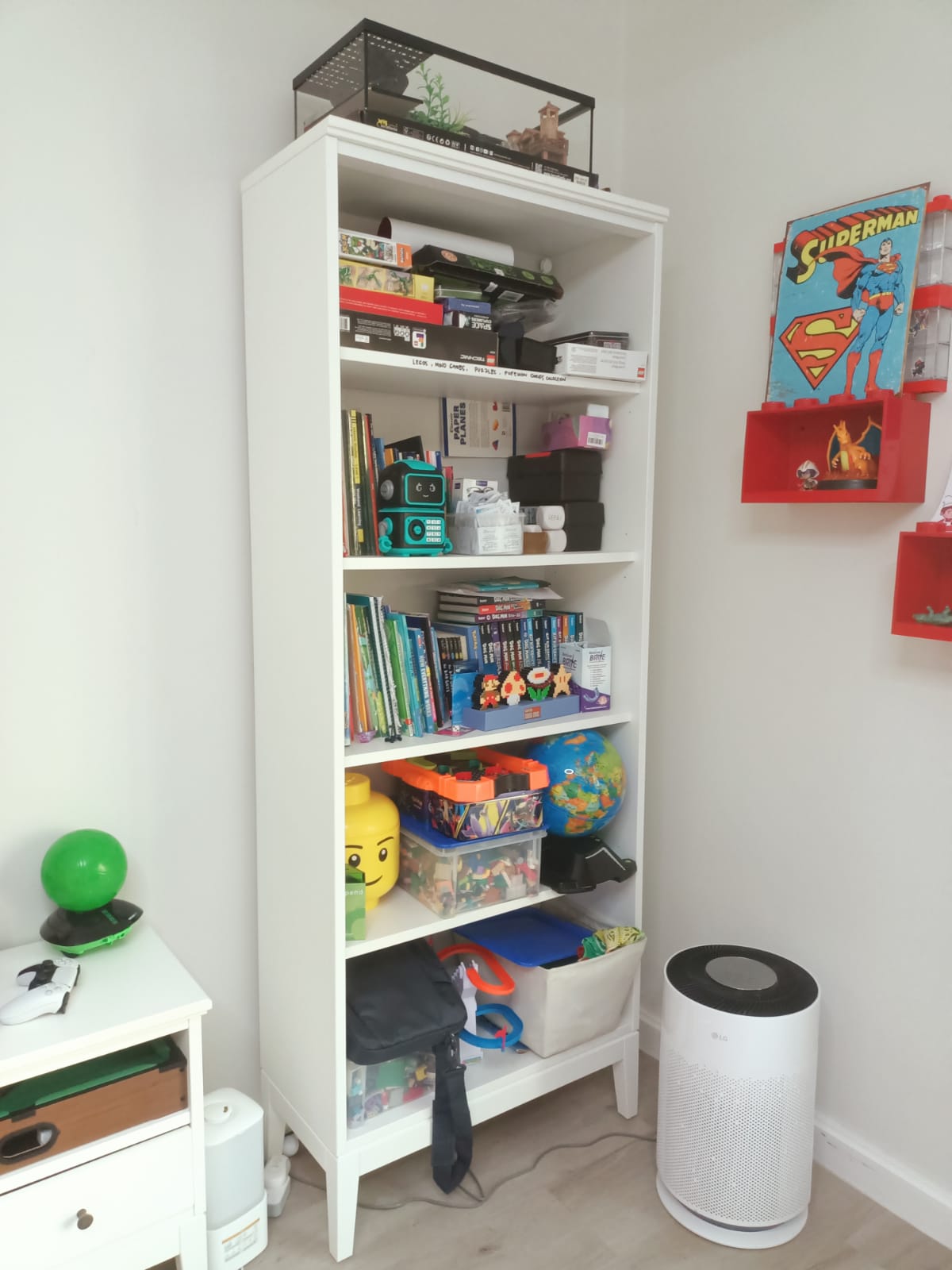 Original photo of tall white bookcase filled with books and toys