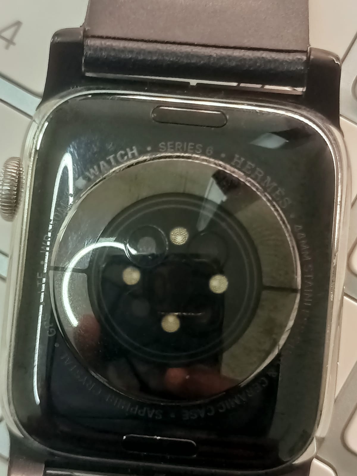Original close-up of the back of a used Apple Watch Series 4 with dark strap