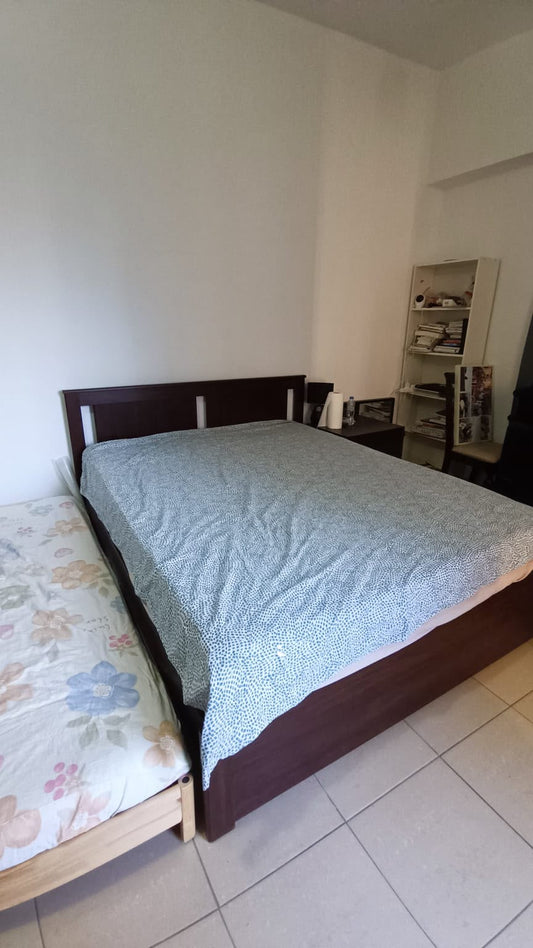 Queen size bed with dark wood frame and mattress