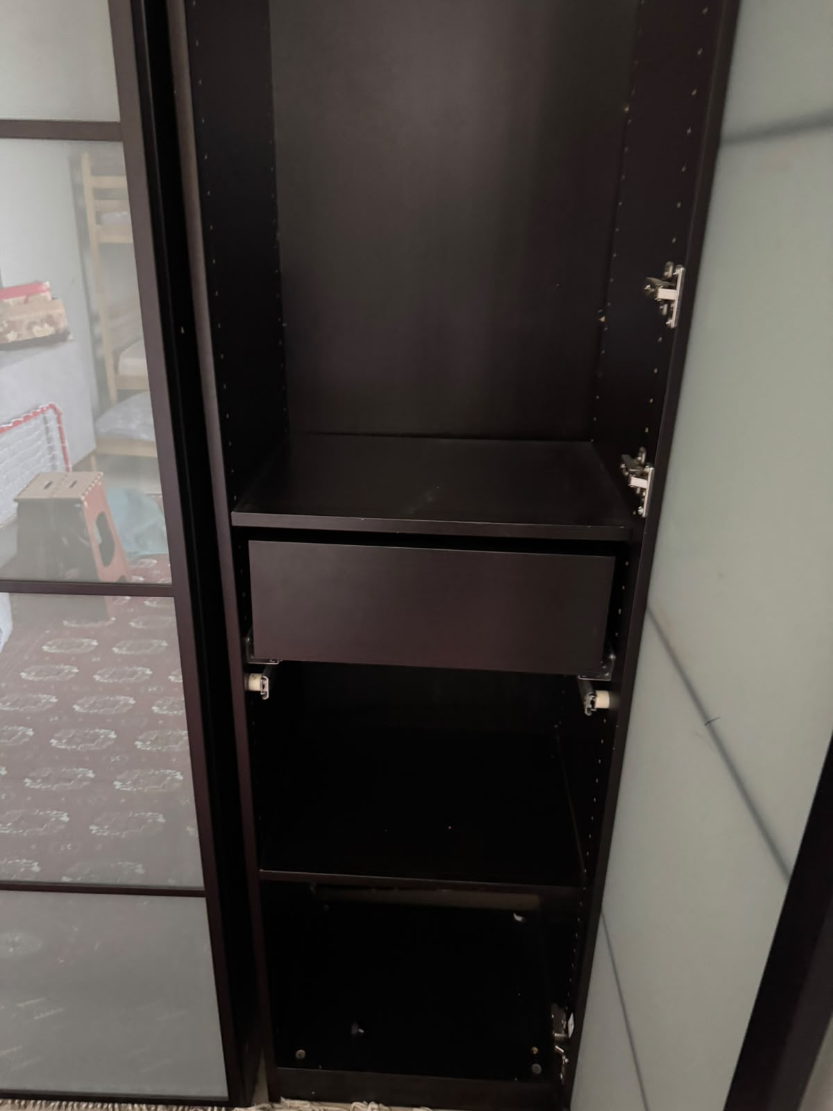 Wardrobe interior showing shelves and drawer unit