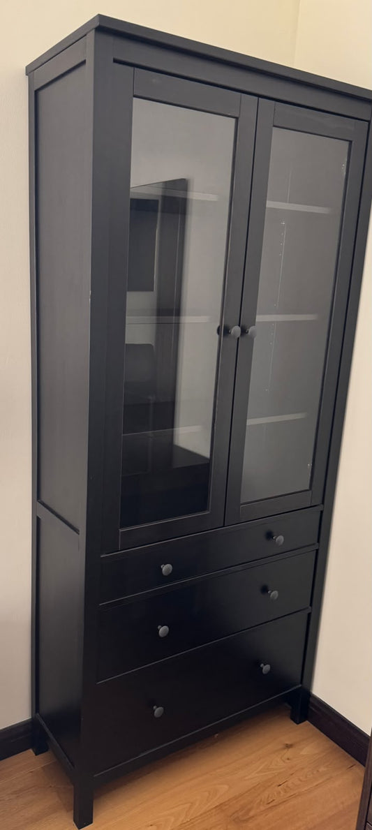 Tall dark wood display cabinet with glass doors and three drawers