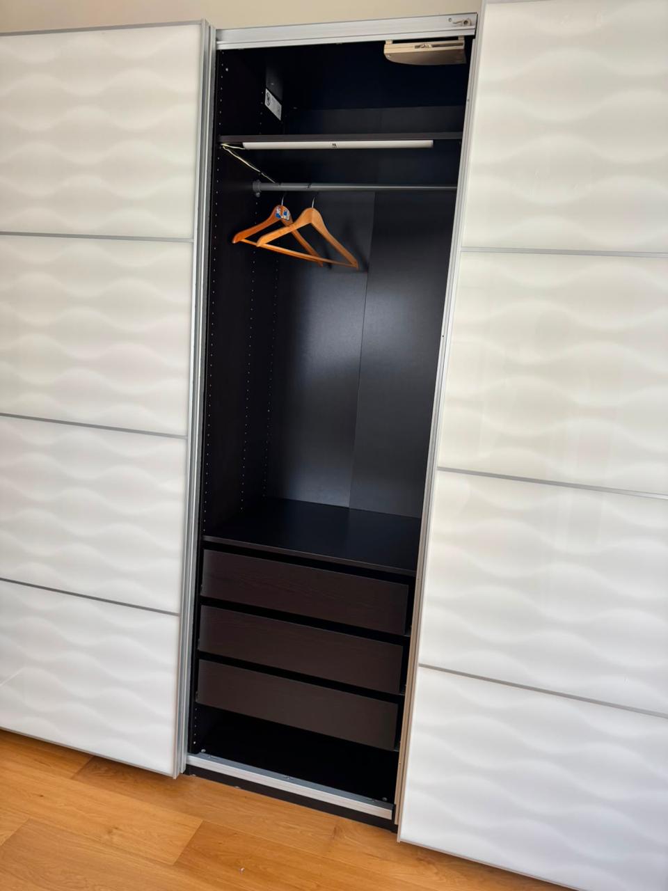 White sliding wardrobe interior showing hanging rail and drawers