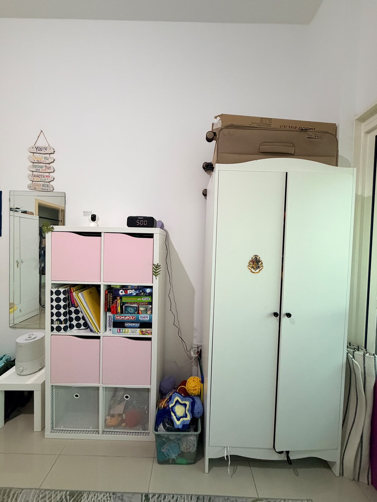 White wardrobe open showing 5 internal shelves filled with clothes