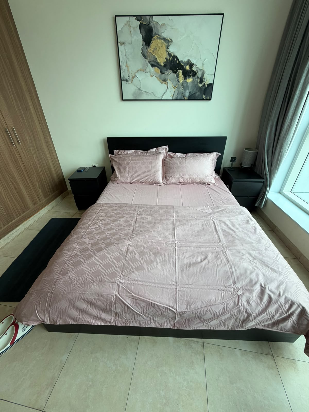 Dark wood platform bed with straight headboard, shown with bedding in a bedroom