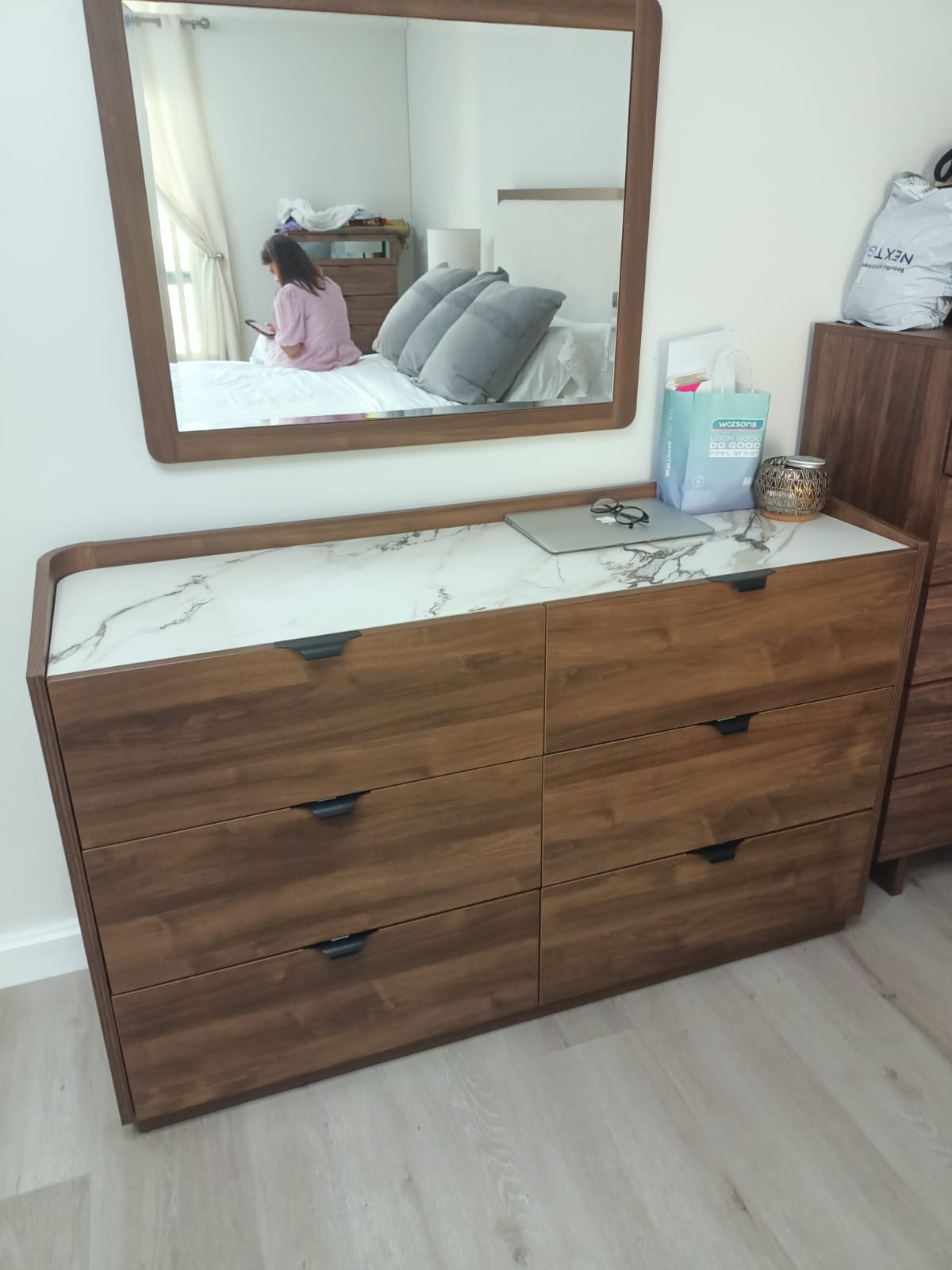 Original photo of wood-look six-drawer dresser beneath wall mirror