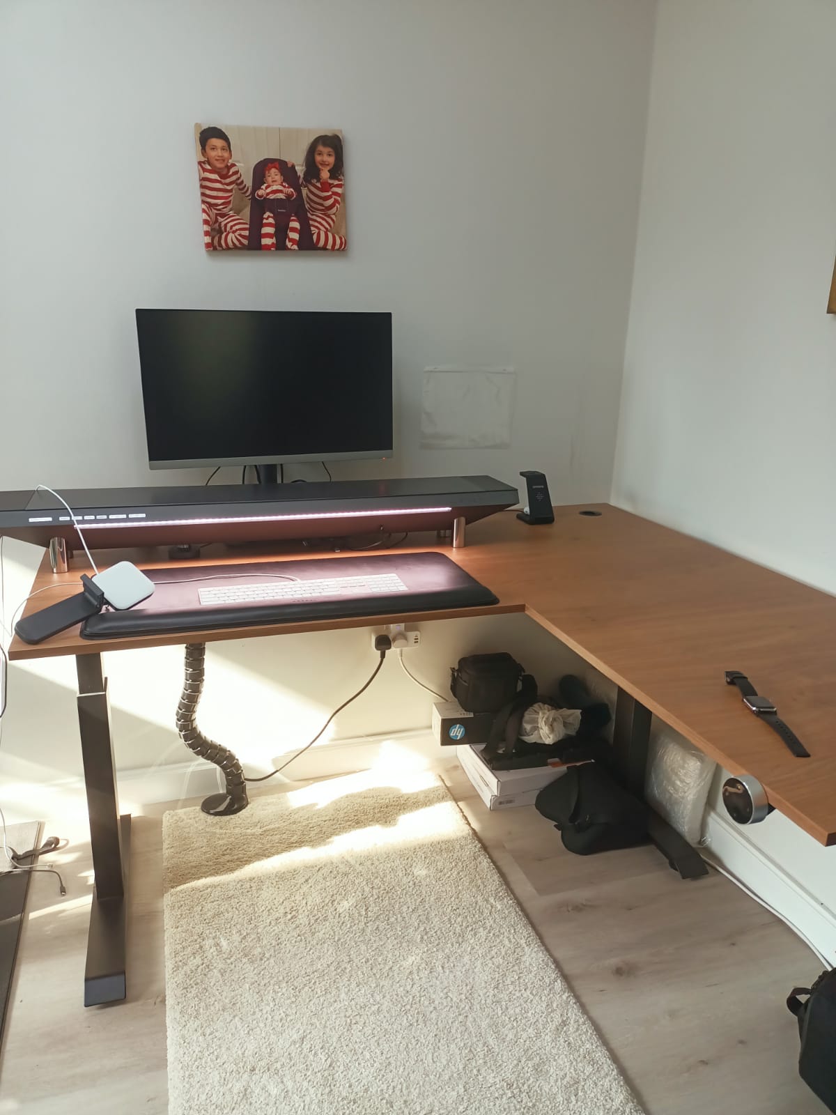 Original photo of L-shaped wood-look adjustable desk with monitor and accessories