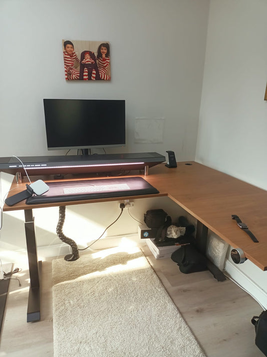 Original photo of L-shaped wood-look adjustable desk with monitor and accessories