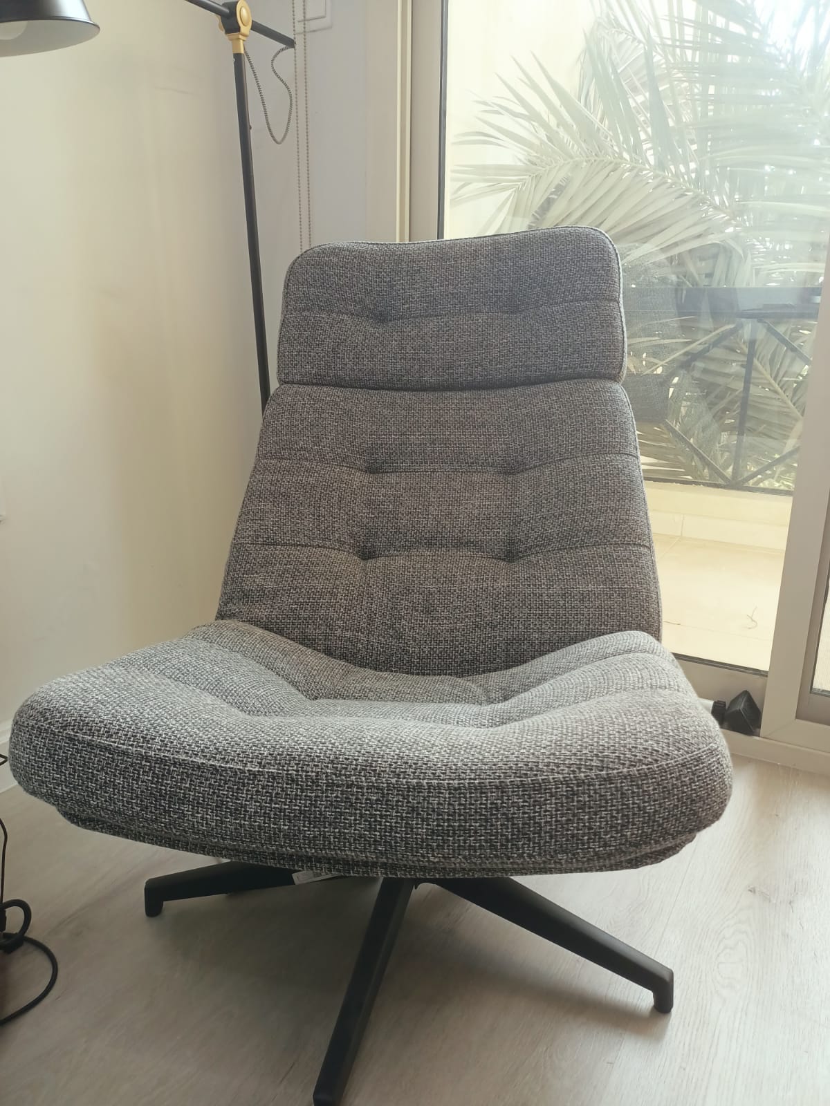 Original photo of grey woven armless lounge chair beside window