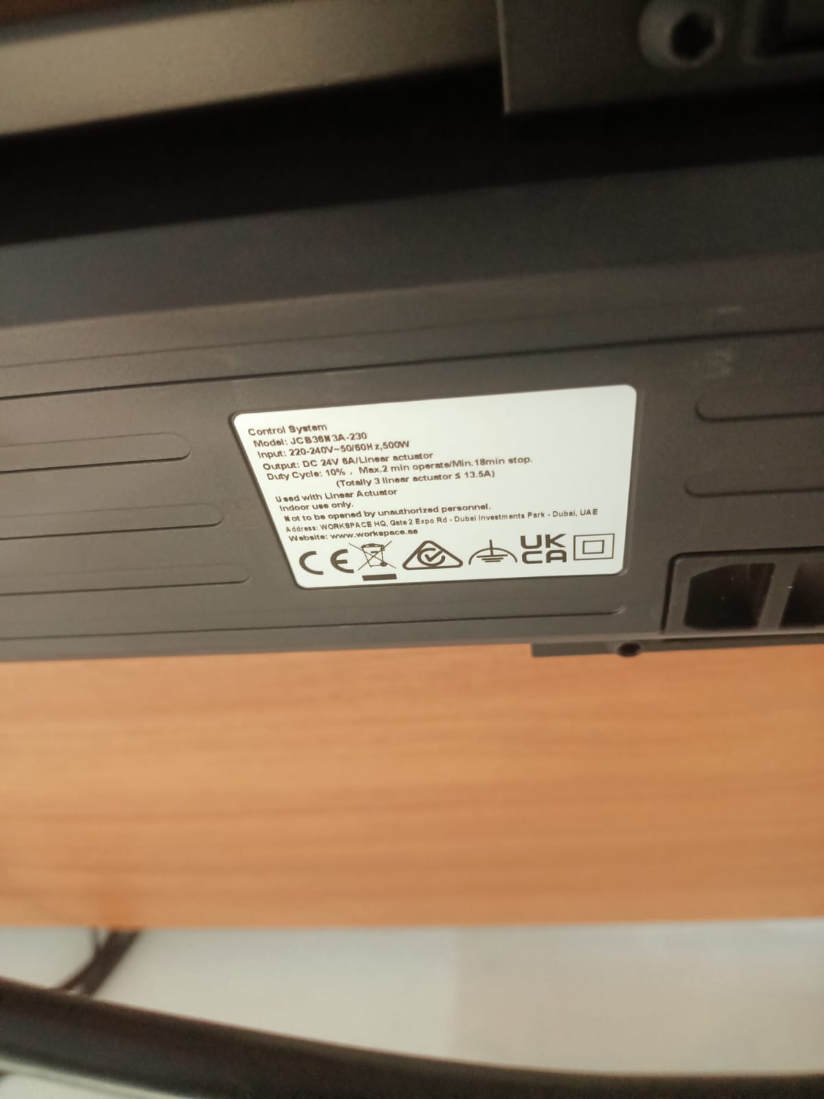 Close-up of control system label beneath electric adjustable desk