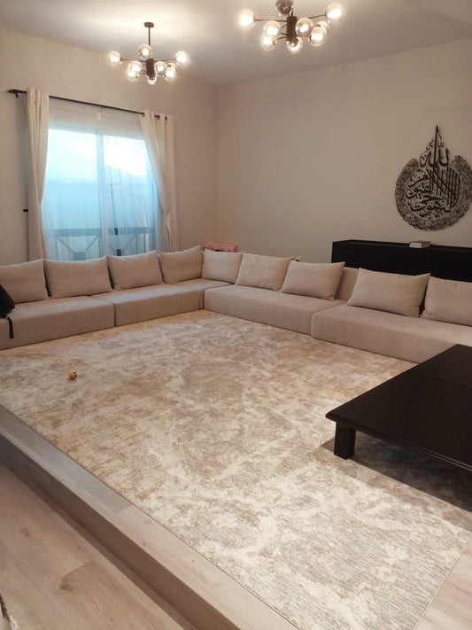 Cream U-shaped majlis sofa set with cushions in a living room