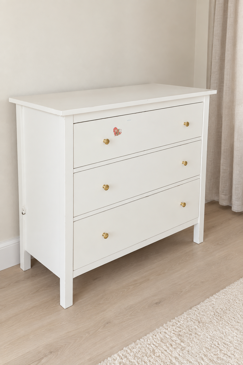 Edited photo of white three-drawer dresser with gold-tone knobs