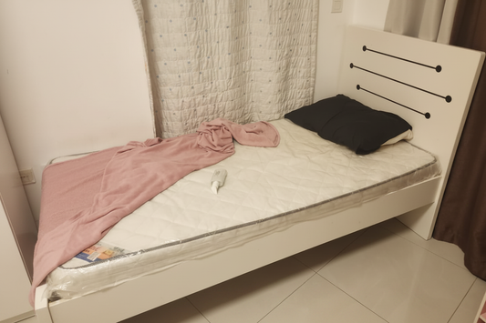 Single white bed frame with black metal rod headboard and mattress